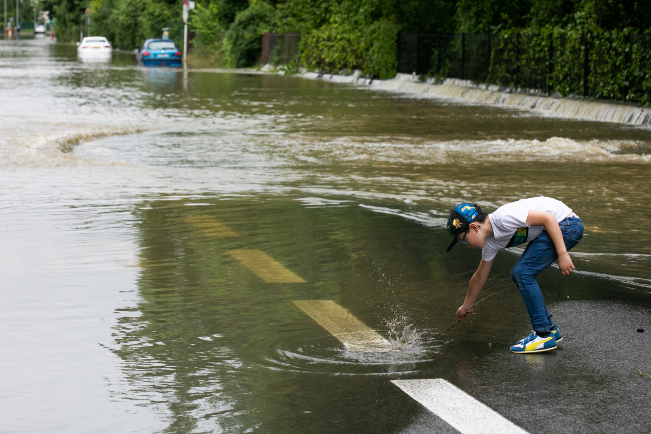 A 15 July photo shows a child next to a flooded Rue de Beggen Photo: Matic Zorman / Maison Moderne