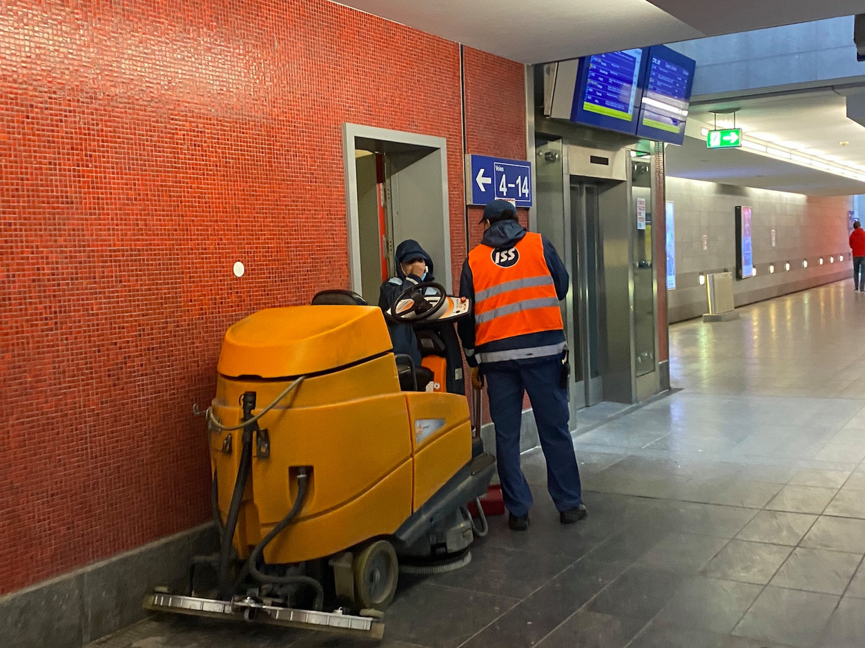 Dans le souterrain, deux employés de nettoyage s’accordent un instant de discussion. (Photo: Paperjam)