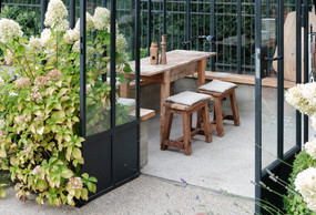 The greenhouse is a real place to live. Whether it's raining or snowing, the warmth invites itself in. In the centre, a table designed with a scaffolding plank forgotten after the works, simple and raw, reflects the authenticity of shared moments. (Photo: PANCAKE! Photography)