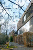 Wood clad façade and continuous glazed bands: a horizontal envelope that captures light, controls views through sunbreakers and subtly dialogues with the wooded landscape. (Photo: Jan Hanrion/Paperjam)