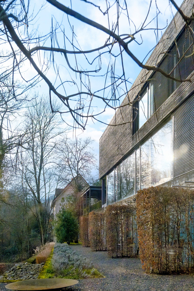 Wood clad façade and continuous glazed bands: a horizontal envelope that captures light, controls views through sunbreakers and subtly dialogues with the wooded landscape. (Photo: Jan Hanrion/Paperjam)
