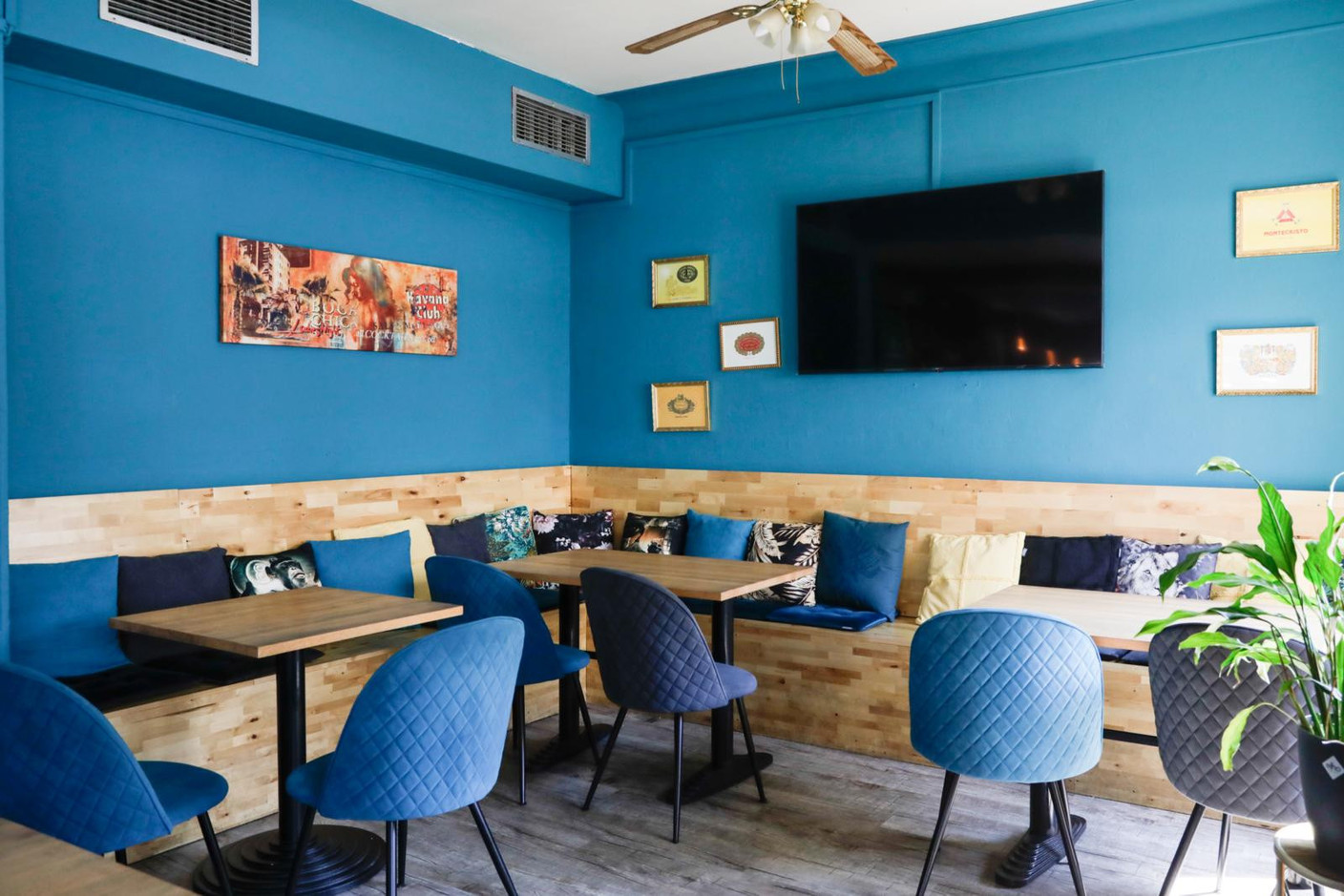 Comfortable benches strewn with cushions, light wood furniture, fabric-upholstered chairs and a variety of pictures on the walls provide the perfect setting to enjoy a simple, unfussy meal. Marie Russillo (Maison Moderne)