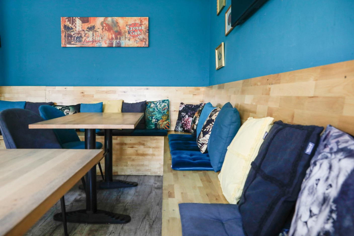 Comfortable benches strewn with cushions, light wood furniture, fabric-upholstered chairs and a variety of pictures on the walls provide the perfect setting to enjoy a simple, unfussy meal. Marie Russillo (Maison Moderne)