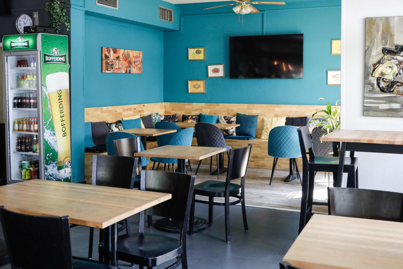 Comfortable benches strewn with cushions, light wood furniture, fabric-upholstered chairs and a variety of pictures on the walls provide the perfect setting to enjoy a simple, unfussy meal. Marie Russillo (Maison Moderne)