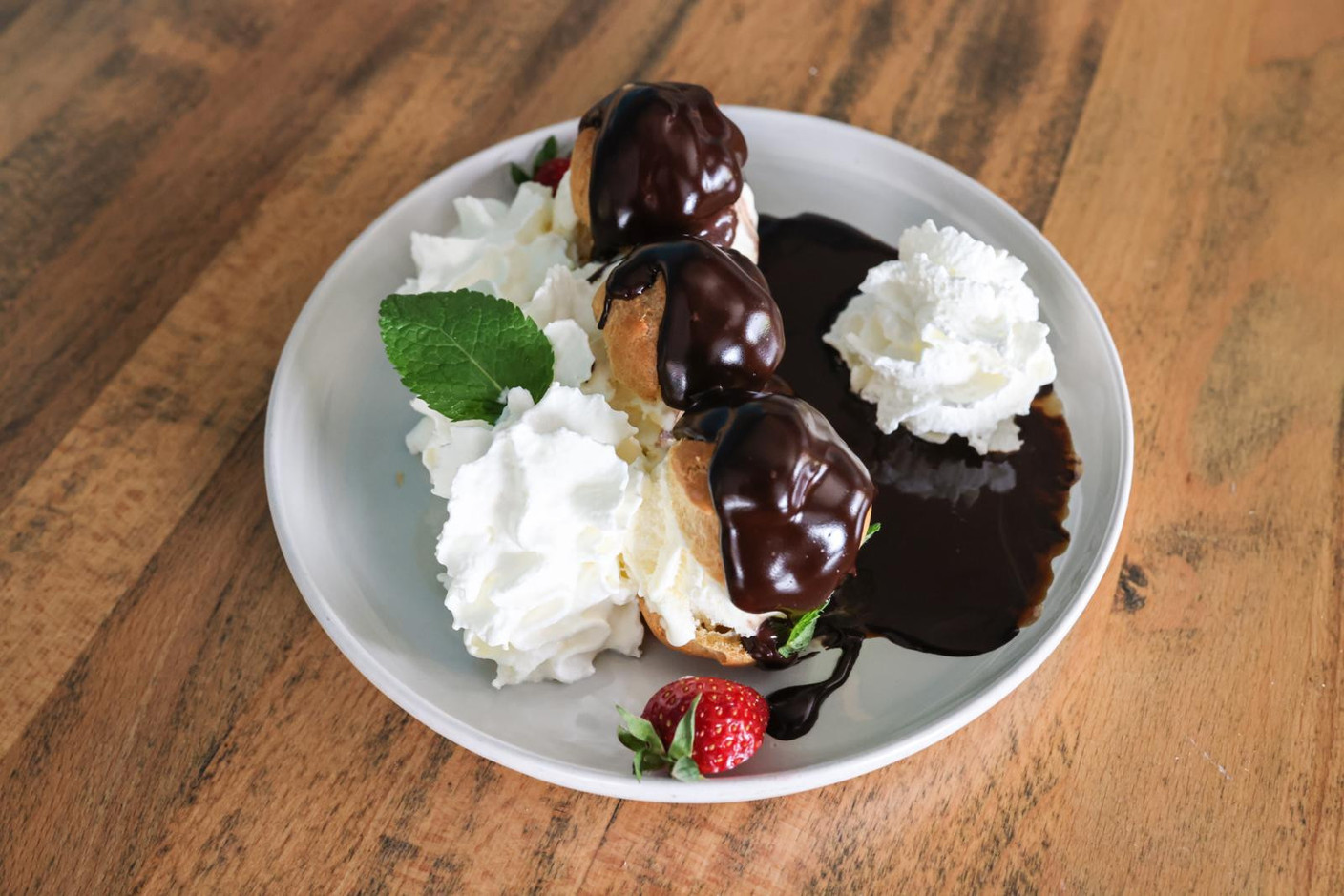 Our meal ends on a deliciously extravagant note with profiteroles covered in chocolate and topped with whipped cream Marie Russillo (Maison Moderne)