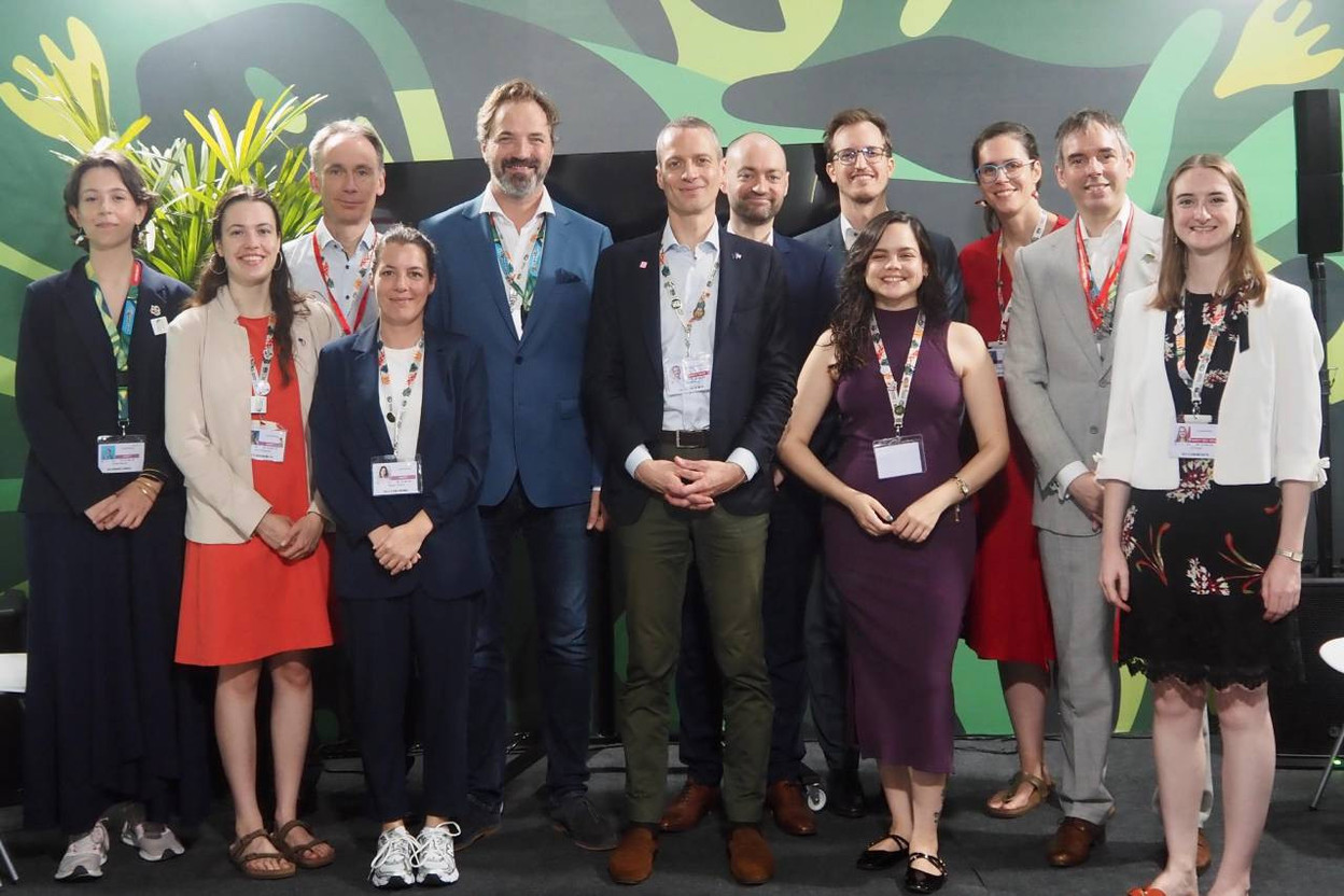 At the COP30 in Belém (Brazil) in November 2025, the Luxembourg delegation posed as part of Luxembourg's presence with its national pavilion. On the far right of the photo, "Climate Youth Delegates" Sarah Mackel and Lara Bertemes surround the minister for the environment, climate and biodiversity, Serge Wilmes (CSV), alongside the other members of the delegation. (Photo: Ministère de l'Environnement, du Climat et de la Biodiversité)