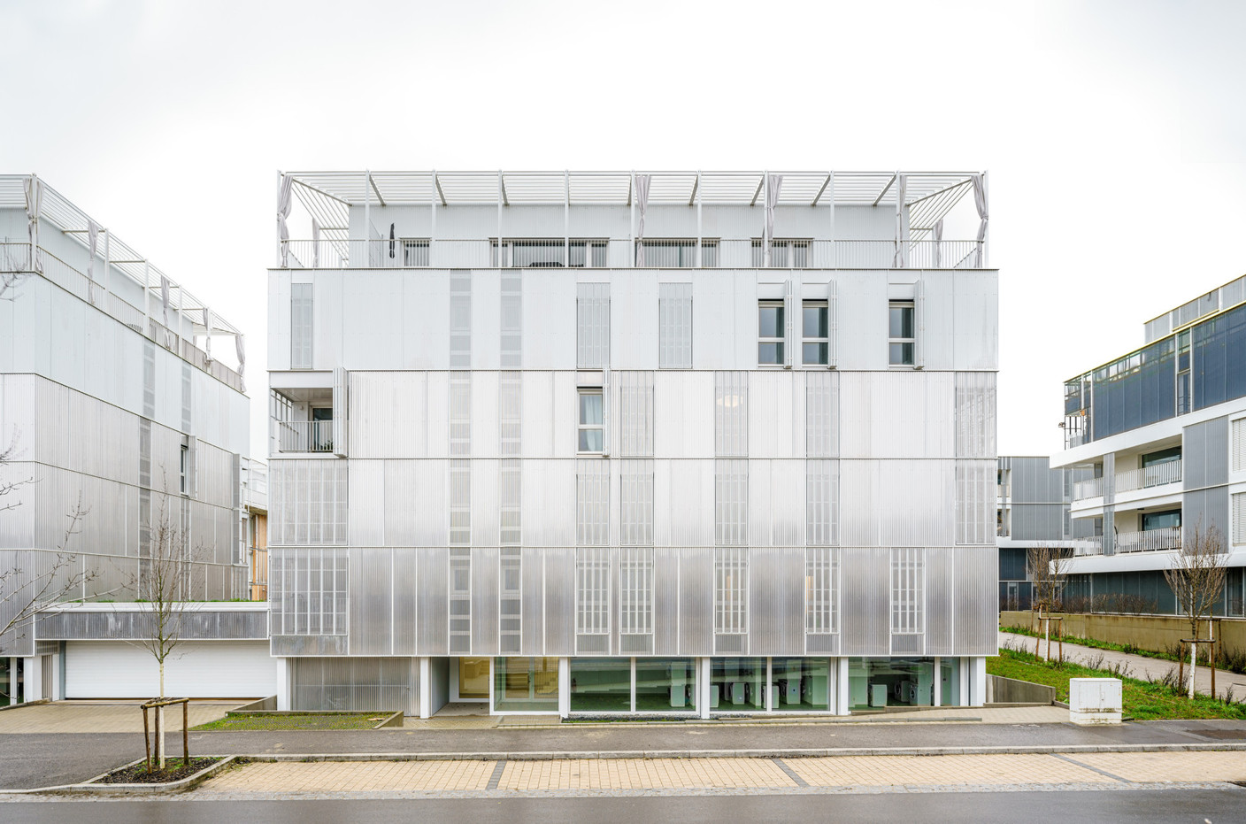 The buildings facing the street have a metal façade. Photo: Miguel Fernández Galiano