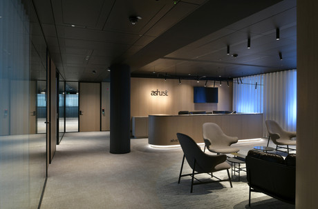 L’accueil des bureaux d’Ashurst LLP est traité avec des panneaux en chêne fumé, dans une atmosphère calme et feutrée. (Photo: Serge Brison)