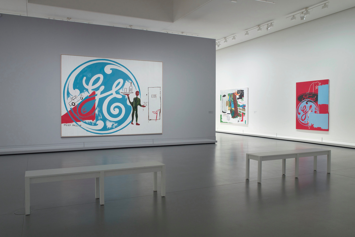 View of the Basquiat × Warhol: Painting four hands exhibition at the Fondation Louis Vuitton, on display from 5 April to 28 August 2023. On the left is General Electric with Waiter. Recognisable logos such as those of General Electric or Ford are visible in the artworks. © Estate of Jean-Michel Basquiat Licensed by Artestar, New York;© 2023 The Andy Warhol Foundation for the Visual Arts, Inc. / Licensed by ADAGP, Paris, © Fondation Louis Vuitton / Marc Domage