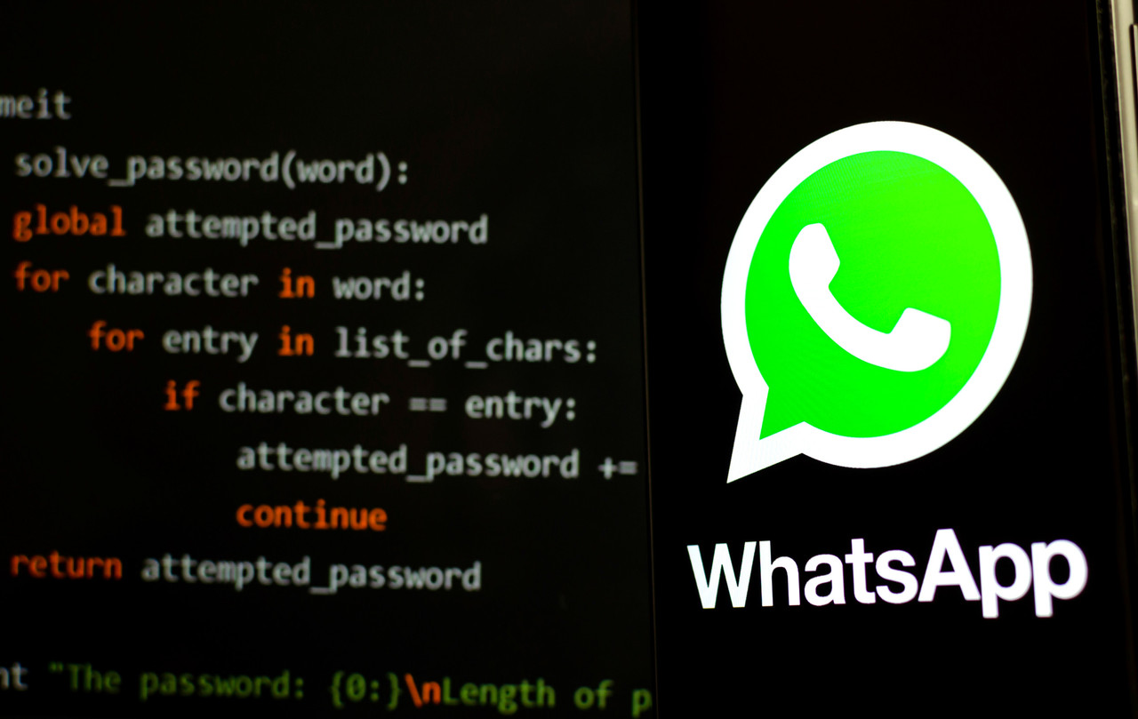 Stone, Staffordshire / UK - October 29, 2019: WhatsApp logo on the smartphone in a dark room and piece of Python code for brute force at the blurred background. Illustrative for WhatsApp hack news. (c) 2019 Ascannio/Shutterstock.