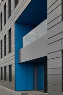 L’entrée du bâtiment est signalée par un volume évidé aux parois bleues qui contrastent avec le reste de la façade. ((Photo: Eric Chenal))