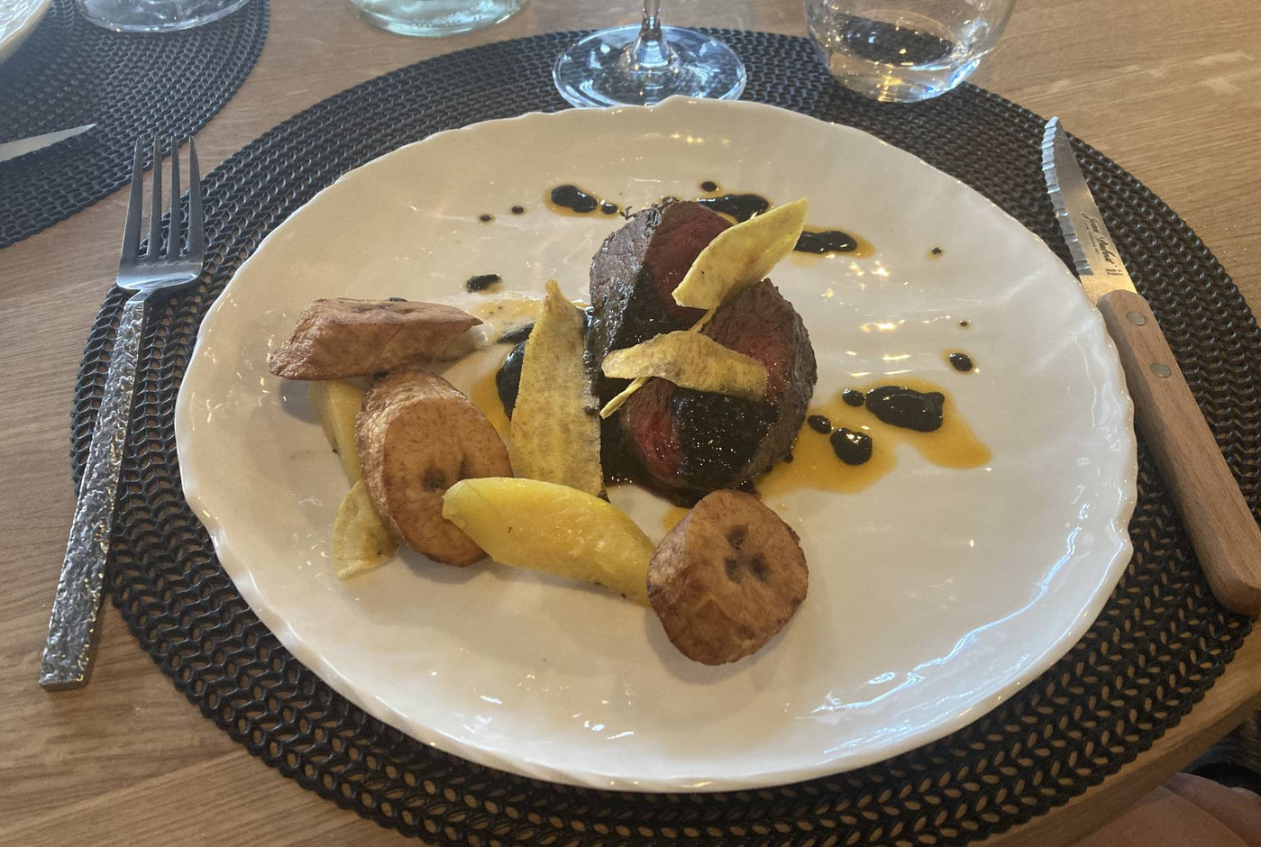 Beef with vegetable charcoal sauce, served with plantain chips, slices and dumplings. Photo: Céline Coubray/Maison Moderne