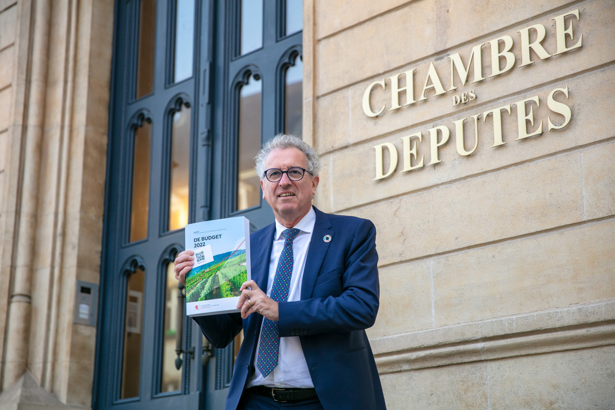 Finance minister Pierre Gramegna holding the 2022 draft budget outside the Chamber of Deputies Photo: Romain Gamba / Maison Moderne