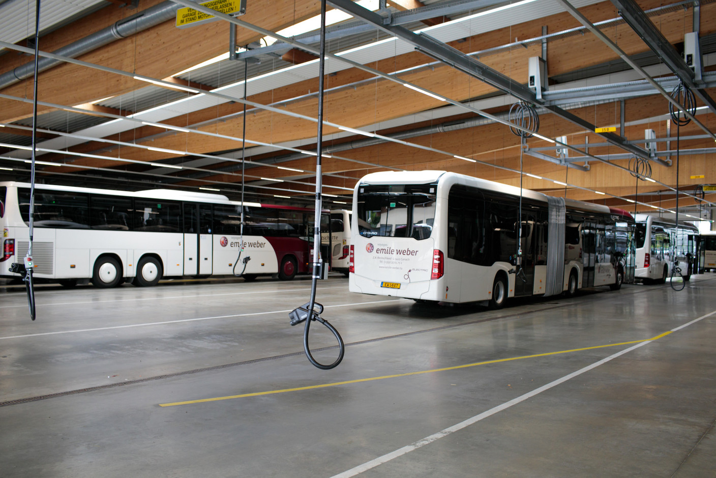 Au plafond, des rails métalliques et un système qui permet d’approcher la prise de tous les endroits où les bus peuvent se brancher. Chaque marque a sa préférence. (Photo: Matic Zorman/Maison Moderne)