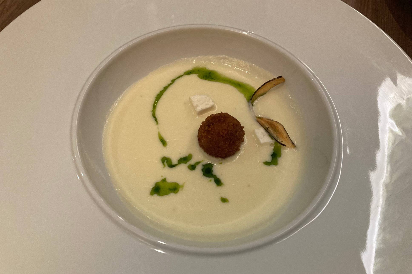 Onctueuse crème de salsifis avec sa croquette de jambon patanegra et une chips de manioc, le tout délicatement relevé par un jus de persil. (Photo: Céline Coubray)