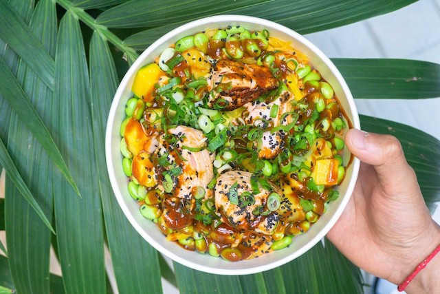 A poke bowl with salmon and fresh vegetables served up by Honoloa Honoloa