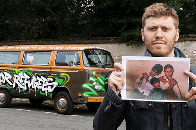 Richters holds a photo of refugee children in front of his team’s campervan, which over 150 have signed Greg Richters