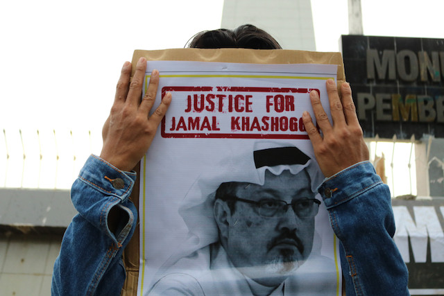 A protestor in Indonesia holds up a banner calling for justice for murdered journalist Jamal Khashoggi Shutterstock