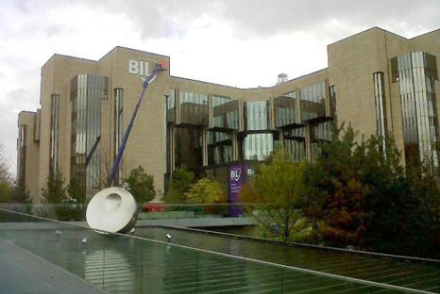 Precision Capital, owned by Qatar’s royal family, could sell its controlling share in Banque Internationale à Luxembourg, Bloomberg has reported. Pictured: A worker installs the then-new logo of Banque Internationale à Luxembourg on its headquarters in Luxembourg City after Precision Capital bought a 90% stake in the bank in 2012. Maison Moderne (archives)