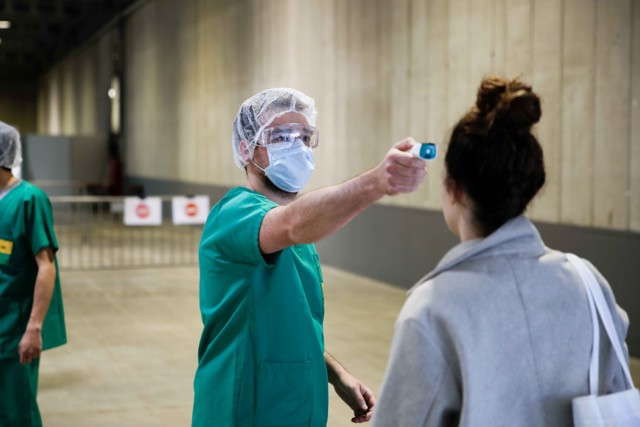 A woman has her temperature taken at the reception area of the advanced medical centre at Luxexpo The Box in Kirchberg. The government is making data sets related to covid testing, hospitalisation and fatalities available for public use. Romain Gamba/Maison Moderne