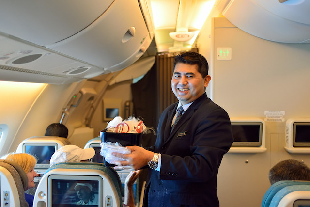 Service with a smill. A Singapore Airlines steward smiles to the camera. Such employees are expected by both the organisation and customers to display the persona of the positive, happy flight attendant Shutterstock