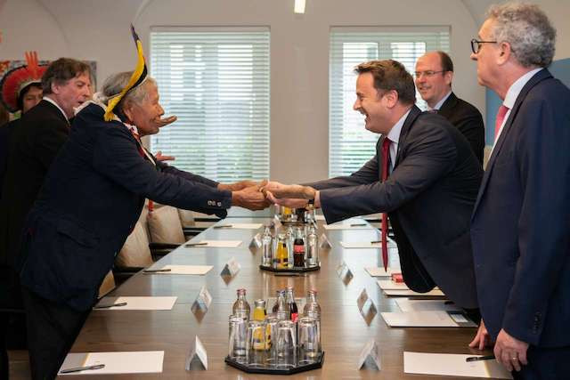 Luxembourg prime minister Xavier Bettel smiles as he shakes hands with chief Raoni Metuktire in Luxembourg on 20 May 2019 Emmanuel Claude/Luxembourg government