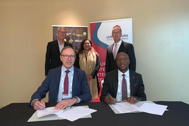 Robert Scharfe (LuxSE) and Oscar N. Onyema (NSE) signing MoU in foreground with WFE representatives Urs Rüegsegger, Nandini Sukumar, and Edward Tilly in the background LuxSE