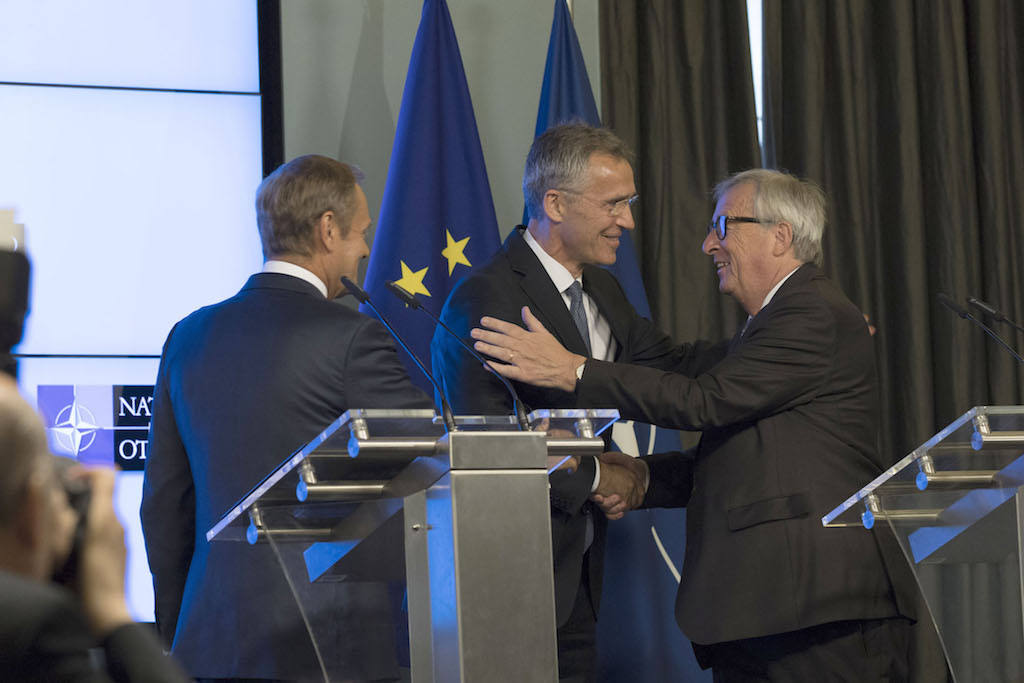 Jens Stoltenberg and Jean-Claude Juncker embrace as Donald Tusk looks on after the signing of a cooperation declaration between Nato and the EU in Brussels on Tuesday Nato