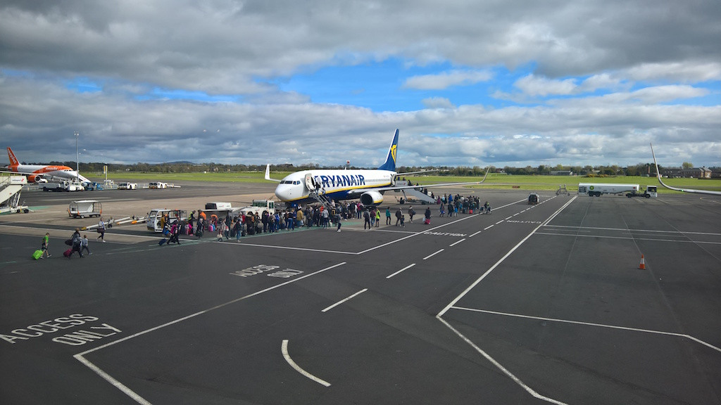 Passengers board a Ryanair flight at Belfast International Airport. Clouds hang over the airline’s summer schedule as pilots and crew threaten strike action. Nick Birse/Wikimedia Commons