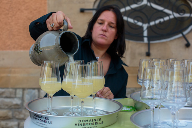A woman pours Fiederwäissen at the Institut Viti-vinicole Matic Zorman
