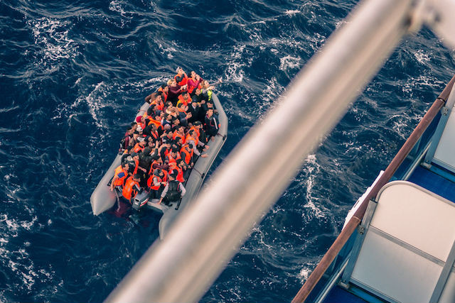 February 2018 photo taken from a cruise ship off the coast of Spain shows migrants in a motorboat calling for help Shutterstock