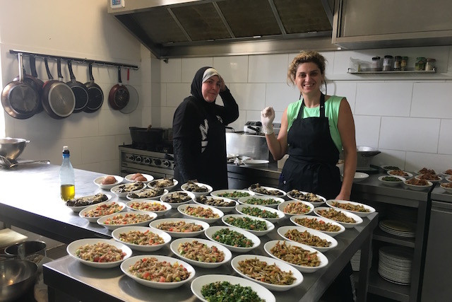 Two women working inside the kitchen at Syriously, a pop-up restaurant in Luxembourg-Hollerich, and the Syrian dishes they prepared, 11 July 2017 Syriously