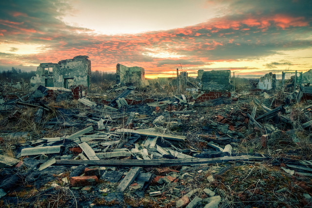 The remains of destroyed houses at sunset Shutterstock