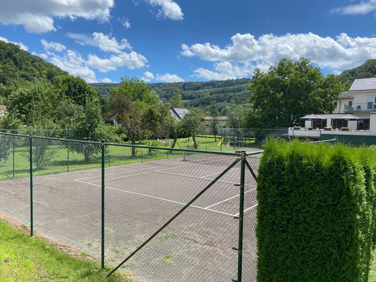 Le court de tennis et, à droite, la terrasse du restaurant. (Photo: Paperjam)