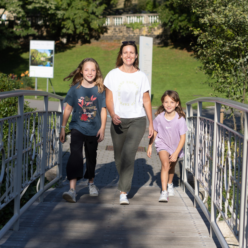 Ananda Kautz (with Mila and Luma) in the thermal park of Mondorf-les-Bains, walking across the bridge that spans the border. Photo: Guy Wolff/Maison Moderne