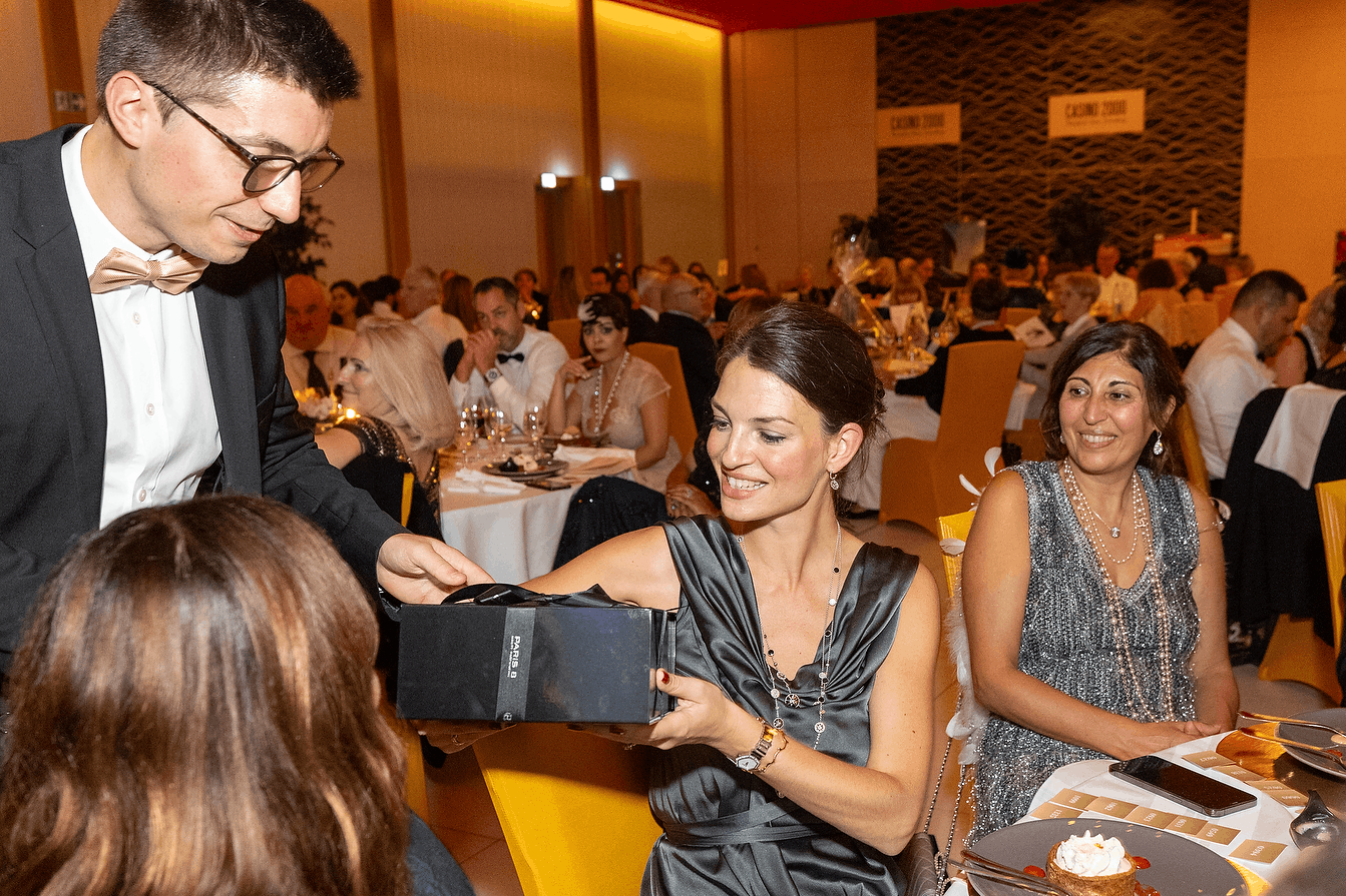 : Max Moreschi presenting a prize to tombola winner, Unda Rossler Dequaire. Photo: Femmes développement / Claude Piscitelli