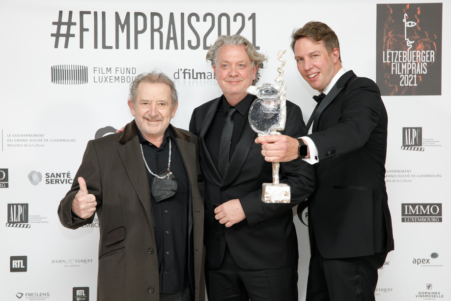 Claude Waringo (centre) at the last Lëtzebuerger Filmpräis, with André Jung (left), the main actor in "Superjhemp retörns", and Félix Koch (right), its director.  (Photo: Matic Zorman/Maison Moderne/archives)