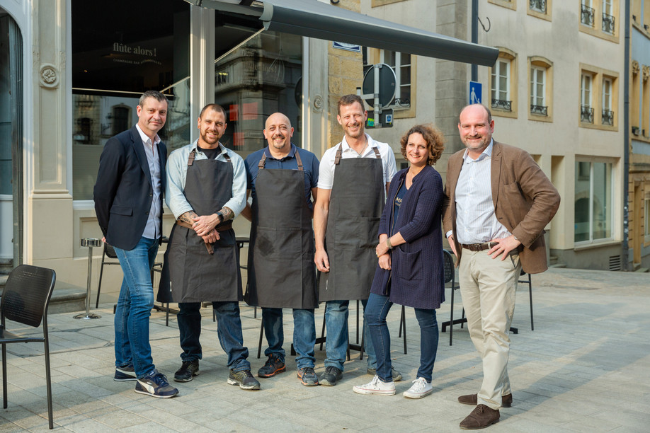 The entire Flûte Alors! team: Rodolphe Chevalier, Hugo Maia, Nenad Jovanovic, Olivier Chocq, Agnès Richer de Forges and Sébastien Rouillaux, in front of their new terrace, just a few steps from the Grand Ducal Palace.  Photo: Romain Gamba / Maison Moderne