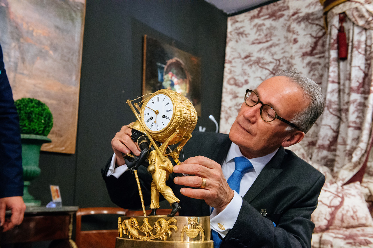 Un expert examine une horloge ancienne. (Photo: Marie De Decker)