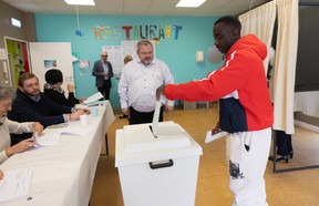 A voter places their ballot in a ballot box at a polling station in Esch-Alzette, 8 October 2023. Photo: Guy Wolff/Maison Moderne