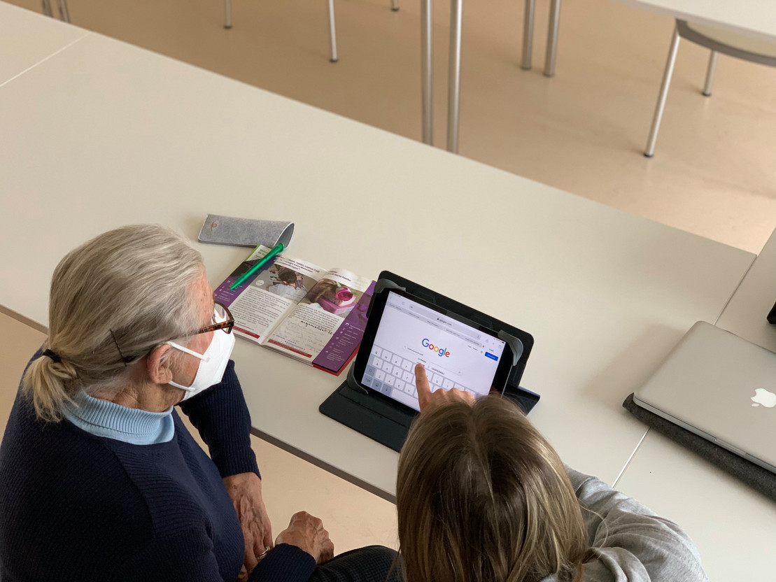 A local teenager shows an older person how to use their iPad to the fullest in a one-to-one session. Credit: GoldenMe