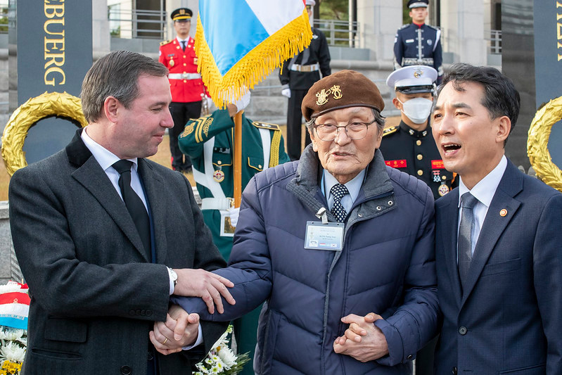 The Crown Prince Guillaume holding the hand of Sungsoo Kim, a Korean War veteran. On the right, Min-sik Park, South Korean minister of patriots and veterans. Photo: SIP / Julien Warnand