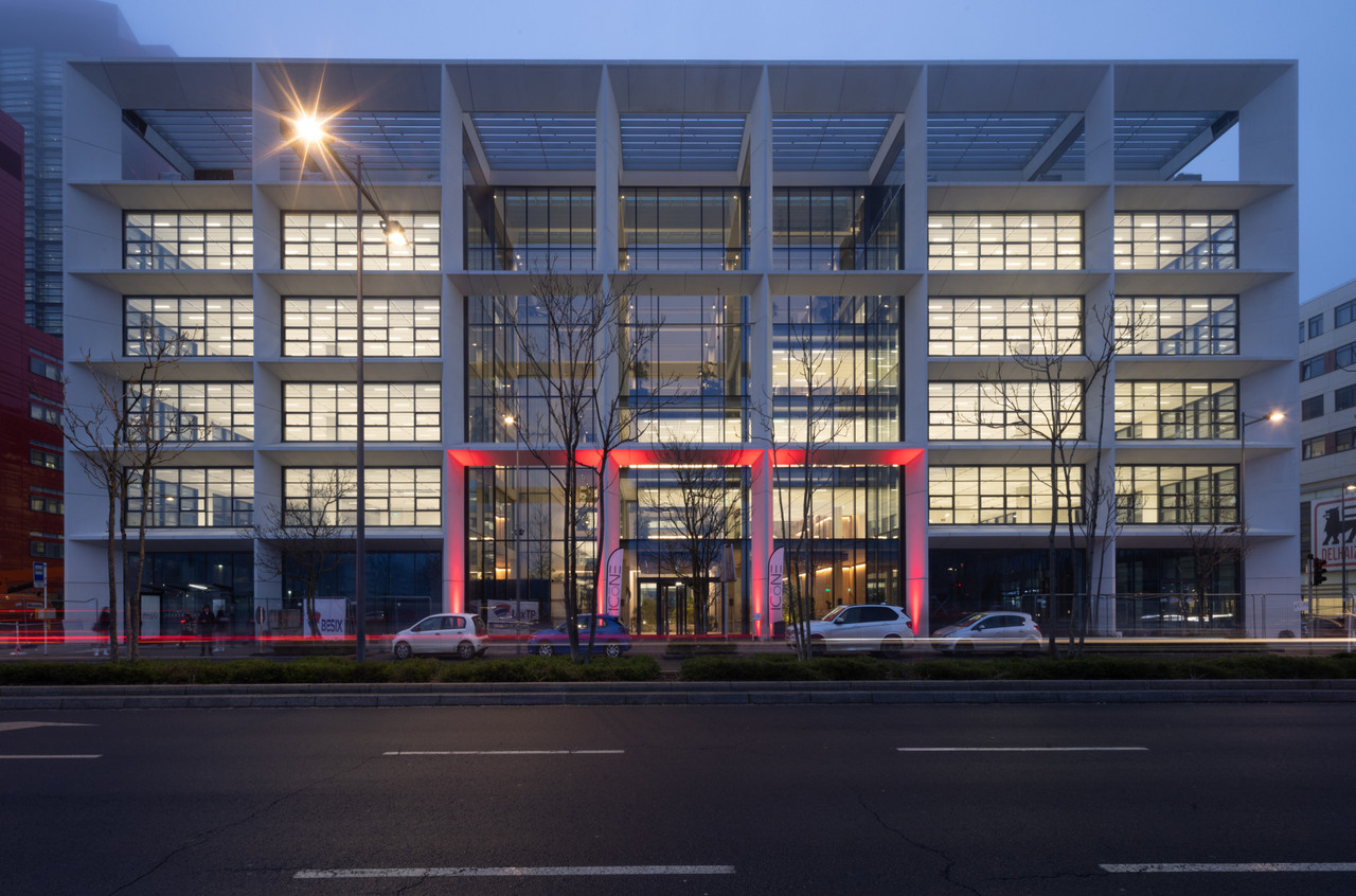 The façade of the building is entirely glazed and has a concrete grid. Guy Wolff/Maison Moderne