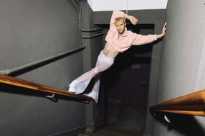 In a 24Colours sweater, Elsie Fred see-through pants and Calvin Klein briefs, he owns the staircase like an afterwork gone deliciously off-track. Photo: Julian Pierrot/Paperjam