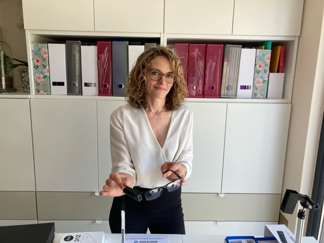 Aurélie Thuin, responsable de Lux Basse Vision présente la technologie Orcam qui aide les personnes atteintes de déficience visuelle. Photo : (Hugo Hirsch / Maison Moderne)