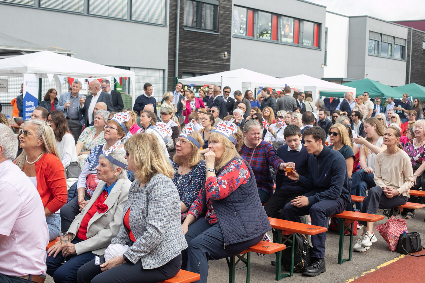 People attending an event at St George’s International School in Luxembourg on 6 May 2023 to celebrate the coronation of King Charles III and Queen Camilla shown on big screens (not shown). Photo: Matic Zorman / Maison Moderne