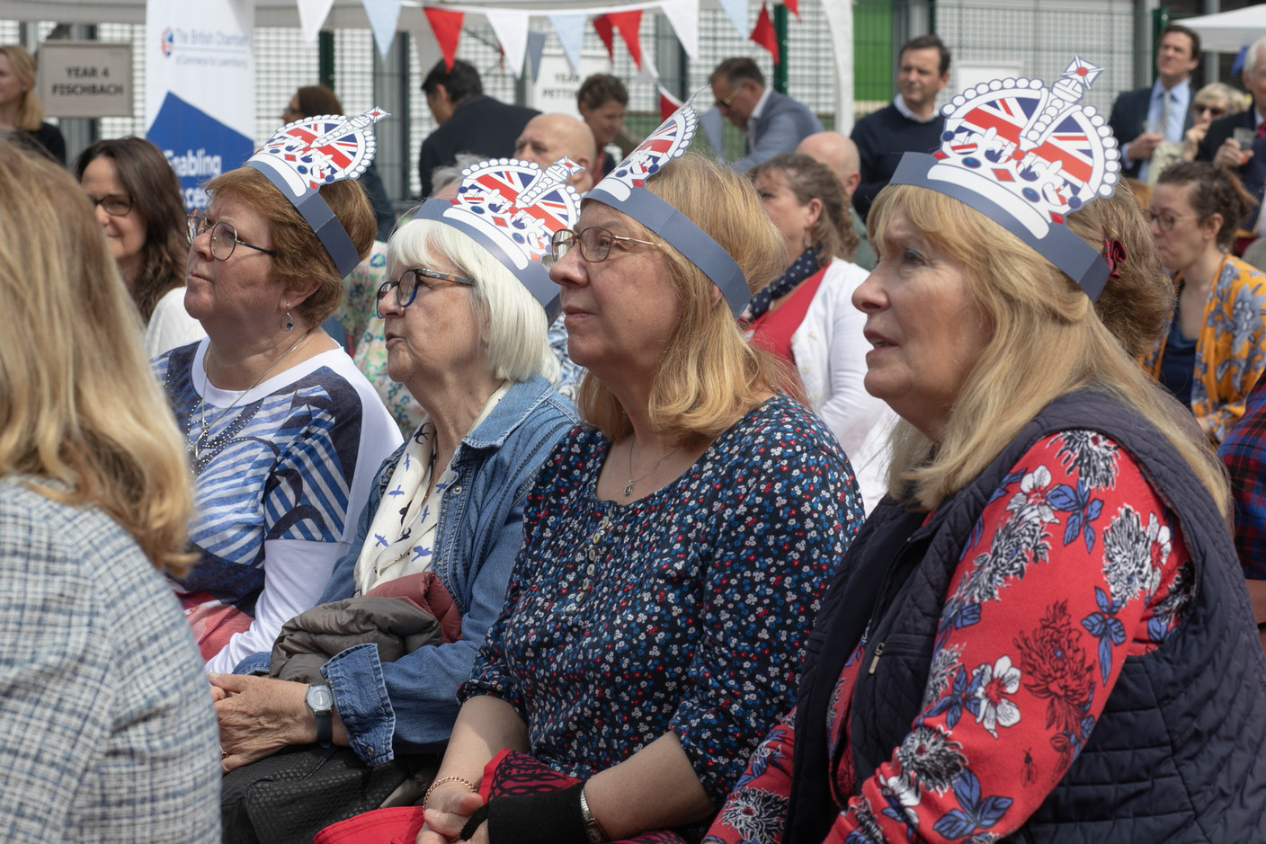People at St George’s International School in Luxembourg watching the coronation service of King Charles III and Queen Camilla shown on  big screens. Matic Zorman / Maison Moderne