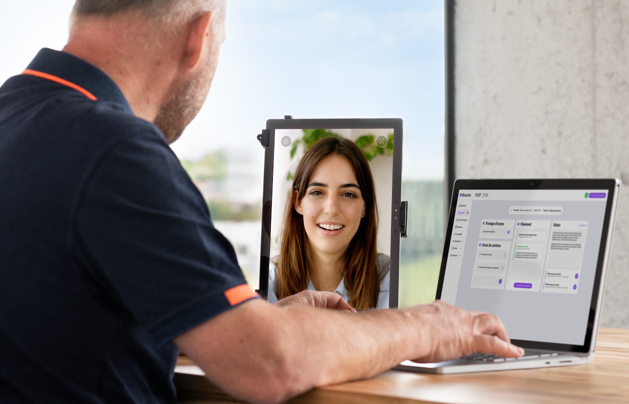 Skalink comprend un terminal (à gauche sur la photo), comme une tablette, pour voir son interlocuteur, et un logiciel qui permet à l’agent de répondre aux questions des clients, même quand il s’agit de modifier un paiement ou un billet et de lui renvoyer directement. (Photo: Aurélien George/Inui Studio)