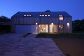 La façade se compose de lamelles en bois traitées comme une façade rideau. ((Photo: Morph4))