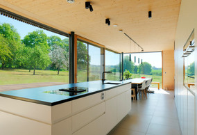 Depuis l’espace de la cuisine, la vue s’ouvre sur le jardin et ses arbres. ((Photo: Morph4))